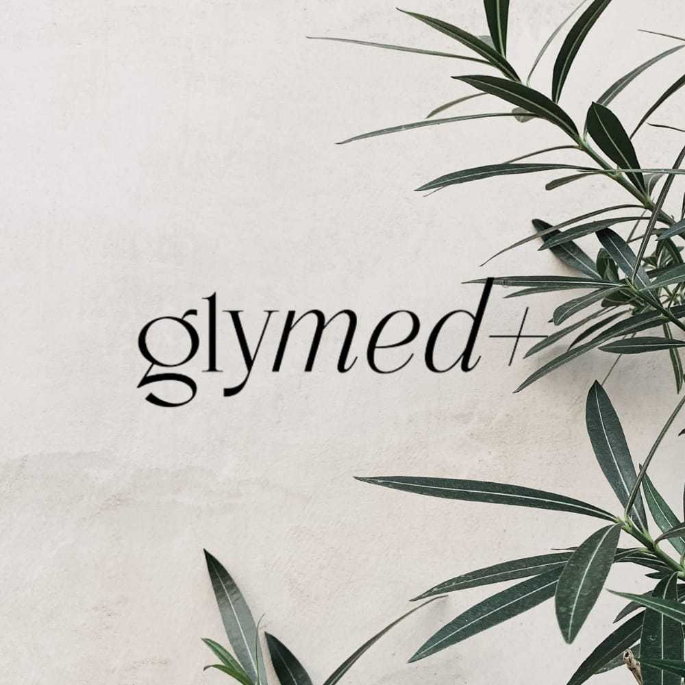 Glymed+ logo on white background with green leaves on the side.