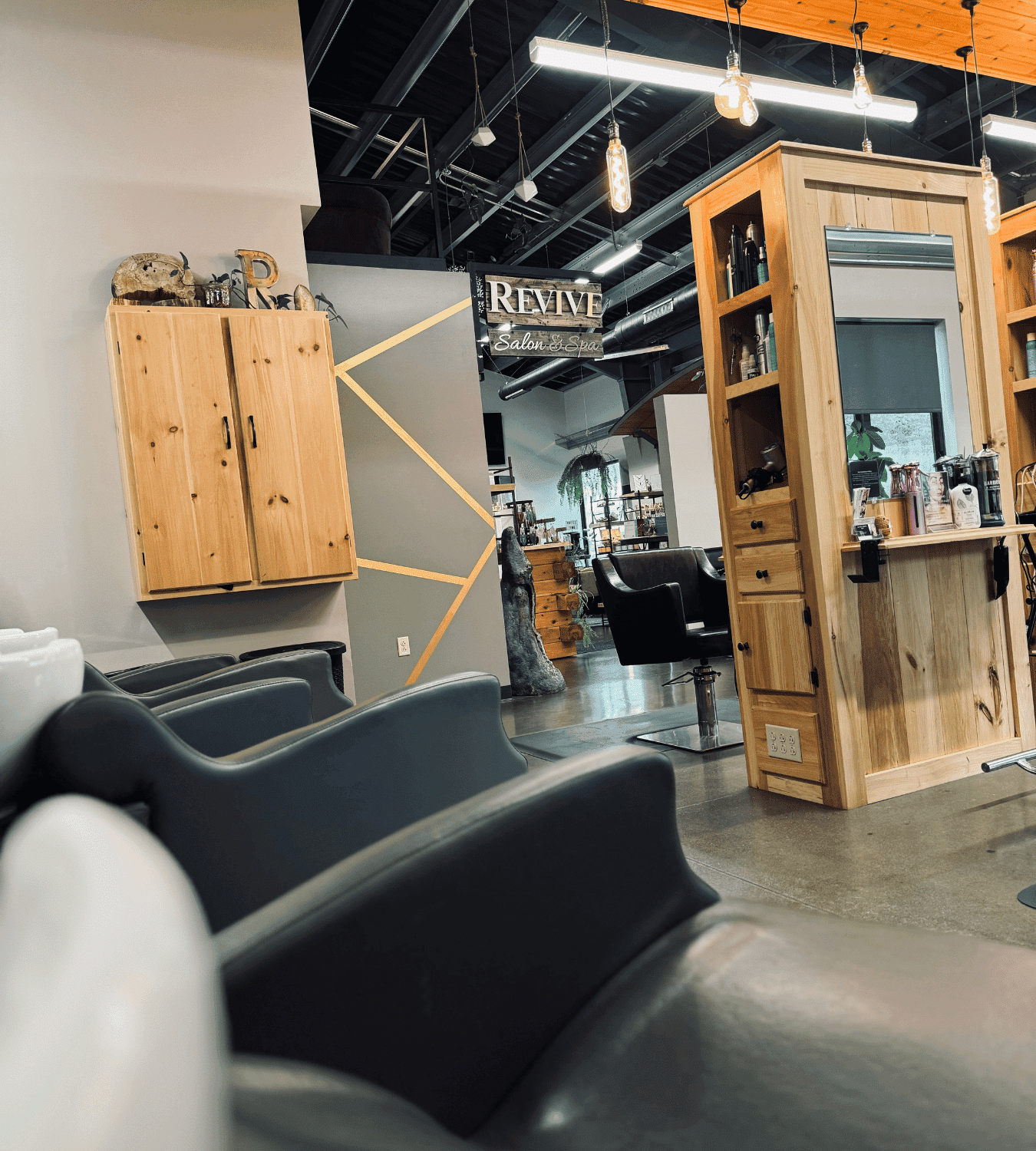Modern hair salon with stylish wooden decor, mirrors, and chairs under warm lighting.