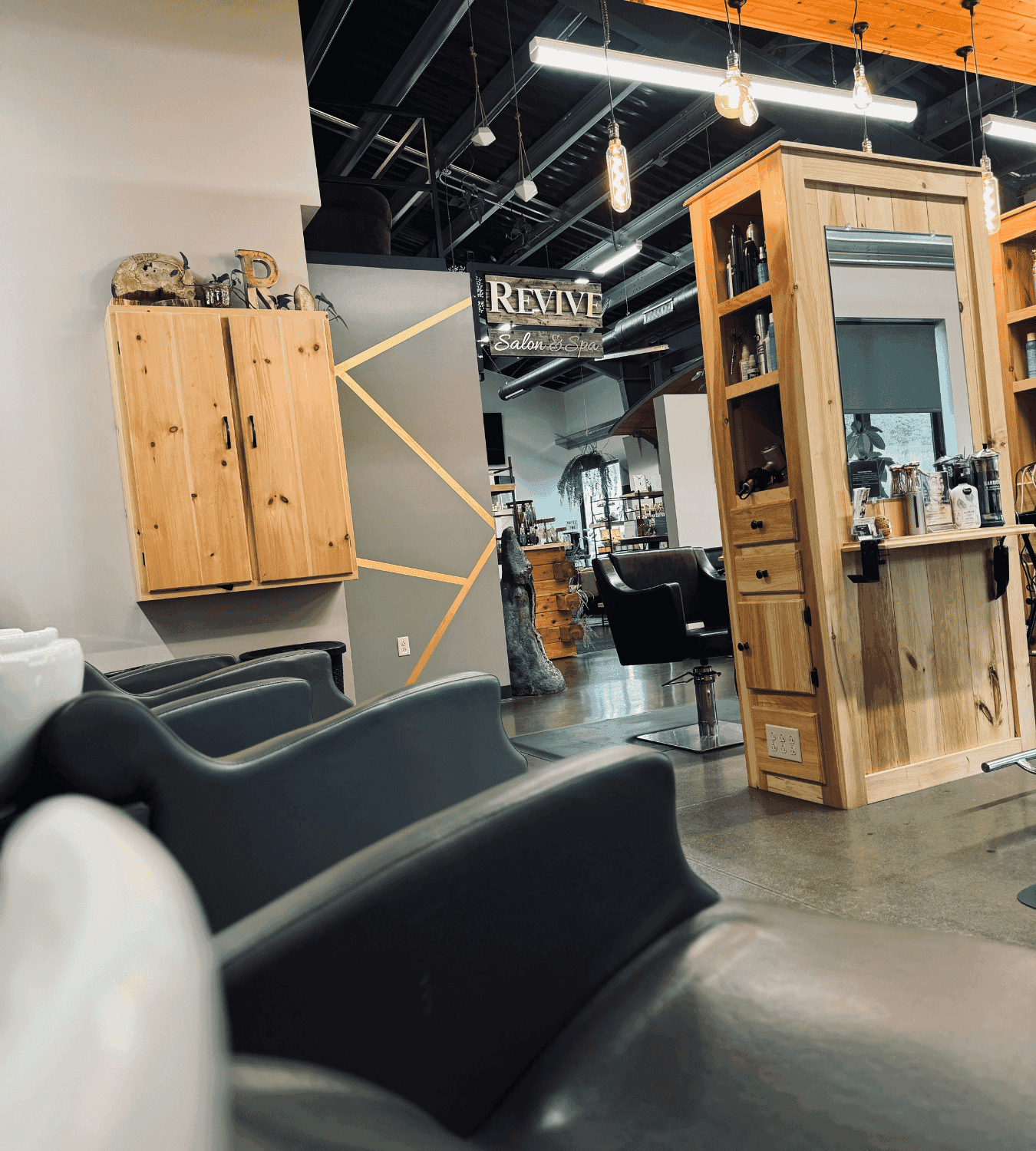 Modern hair salon with stylish wooden decor, mirrors, and chairs under warm lighting.