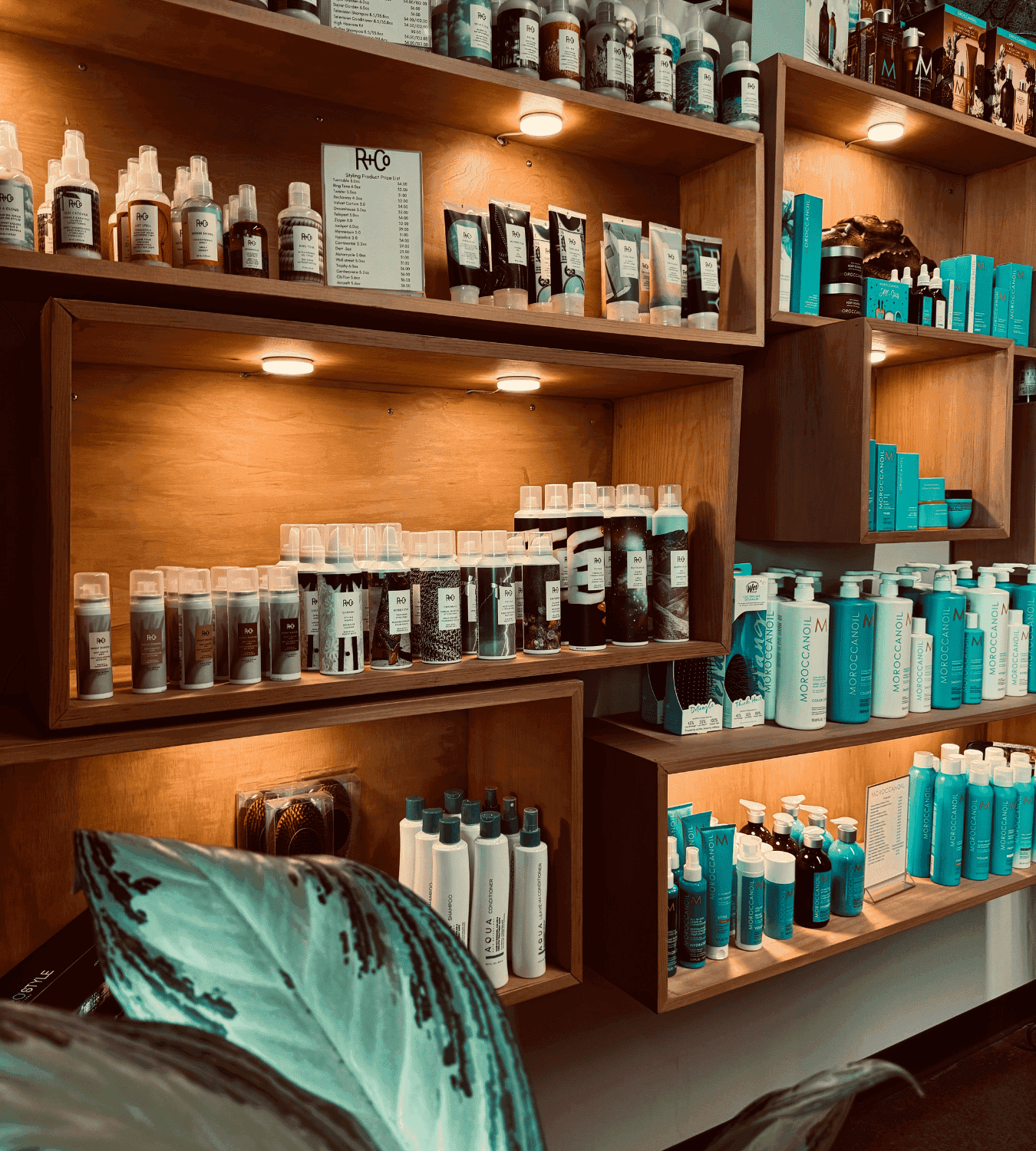 Shelves displaying various hair care products in a warmly lit wooden shelving unit.