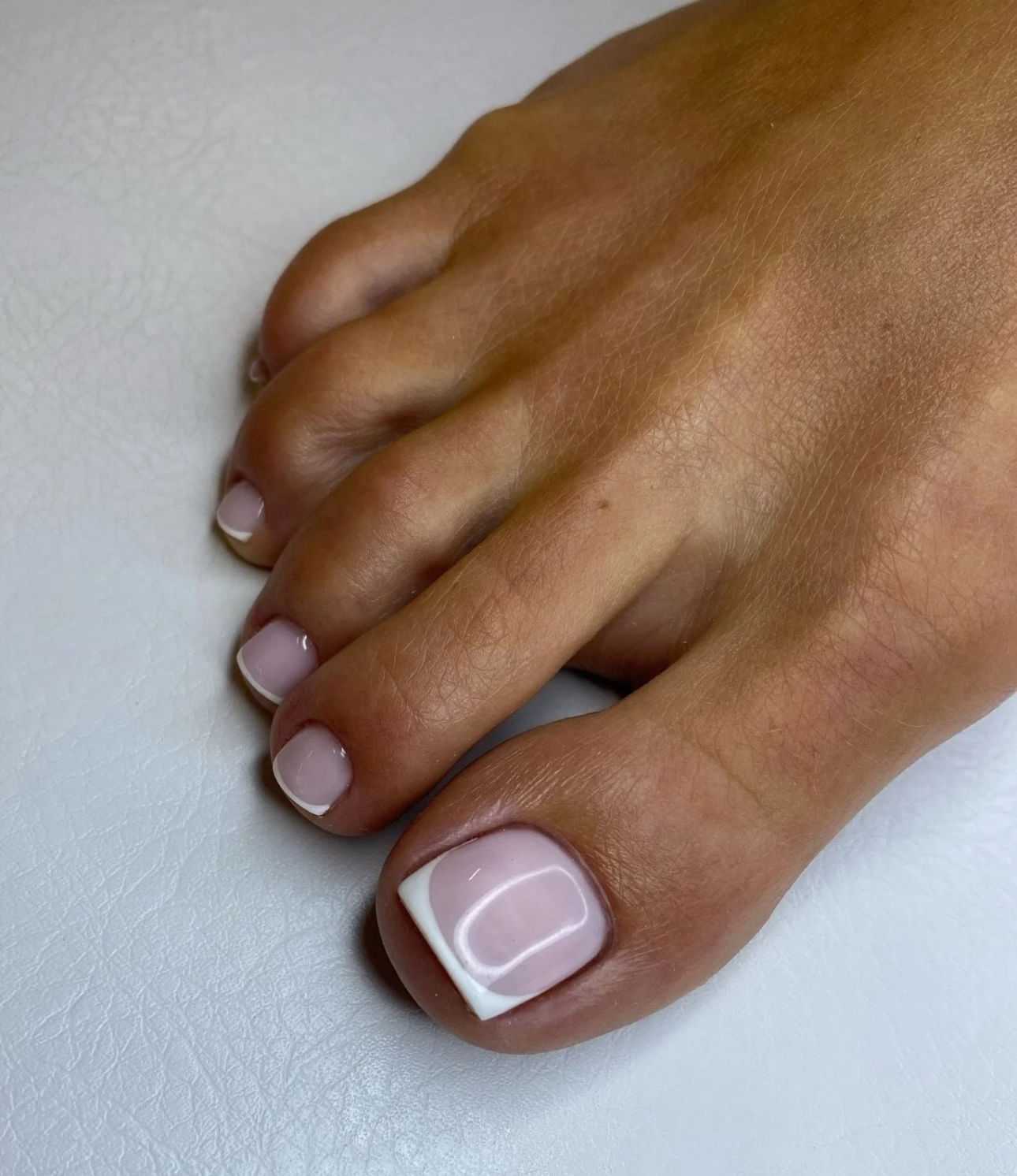 French pedicure on toenails with a glossy finish.