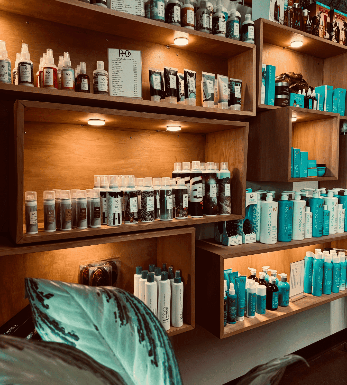 Shelves displaying various hair care products in a warmly lit wooden shelving unit.